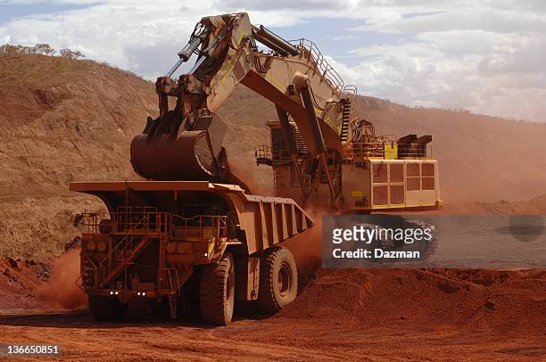 excavator loading ore into a haul truck. - dumper truck stock pictures, royalty-free photos & images