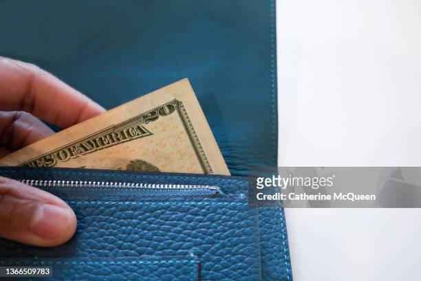 black woman holding vibrant blue wallet with $20 u.s. paper bill showing - american twenty dollar bill stock pictures, royalty-free photos & images