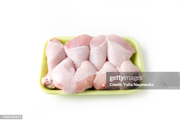 raw chicken drumsticks wrapped on a white background - raw chicken stockfoto's en -beelden