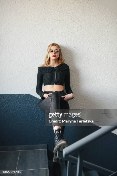 a beautiful blonde girl stands on the steps. casual style. curly hair. girl in glasses. glasses in the form of fire. - curly blonde hair woman stock pictures, royalty-free photos & images