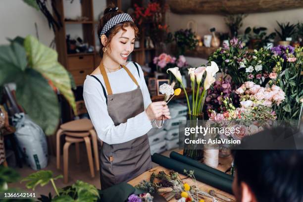 joven florista asiática, propietaria de una floristería de pequeñas empresas, haciendo un taller de jamming floral, dando un tutorial sobre arreglos de ramos de flores a los estudiantes. pequeña empresa, taller de arte y artesanía, concepto de pasatie - arreglo floral fotografías e imágenes de stock