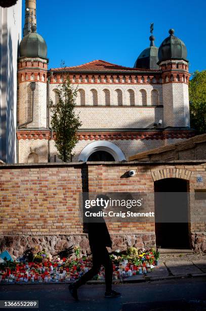Member of the public walks by remembrance flowers laid outside the Synagogue on Humbold Strasse, Halle , Germany on October 12th 2019. Four days...