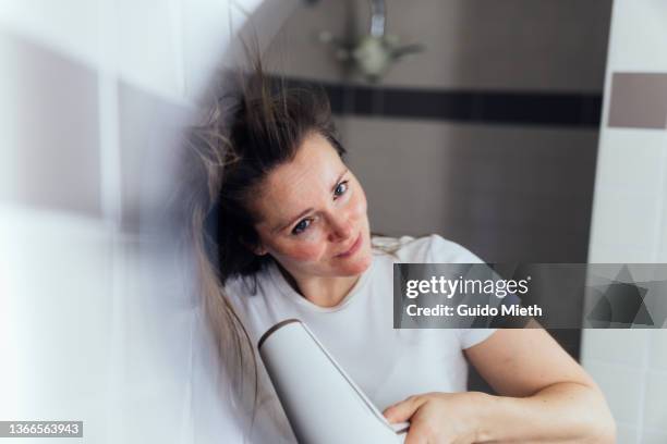 woman drying her hair at home in bathroom. - haarpflege stock-fotos und bilder