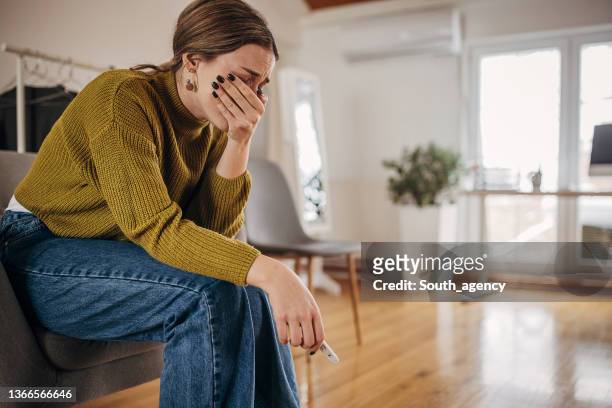disappointed woman crying because pregnancy test is negative again - miscarriage stock pictures, royalty-free photos & images