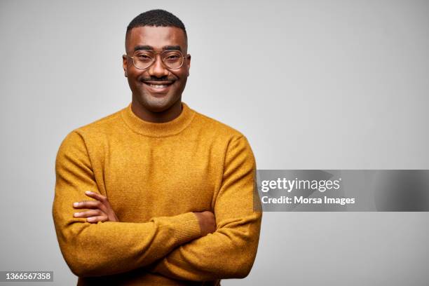 smiling african american confident businessman standing with arms crossed. - schwarzes hemd stock-fotos und bilder