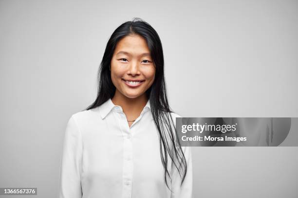 portrait of japanese smiling woman with long hair - woman white shirt stock-fotos und bilder