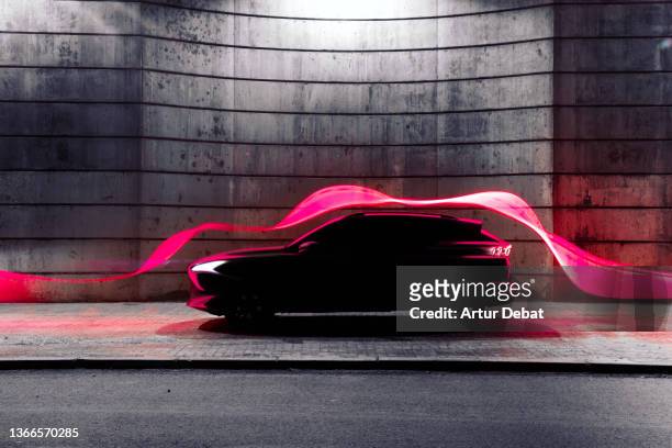modern car with futuristic aerodynamic red light trail flowing in cool stage. - aérodynamique photos et images de collection