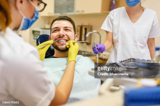 man at the dentist braces check up - orthodontics stockfoto's en -beelden