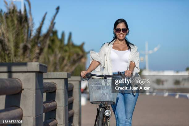 happy ethnic woman with bicycle on seashore - boardwalk beach stock pictures, royalty-free photos & images