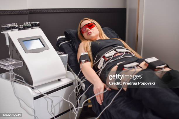 liposuction laser therapy in beauty salon - celulite stock pictures, royalty-free photos & images