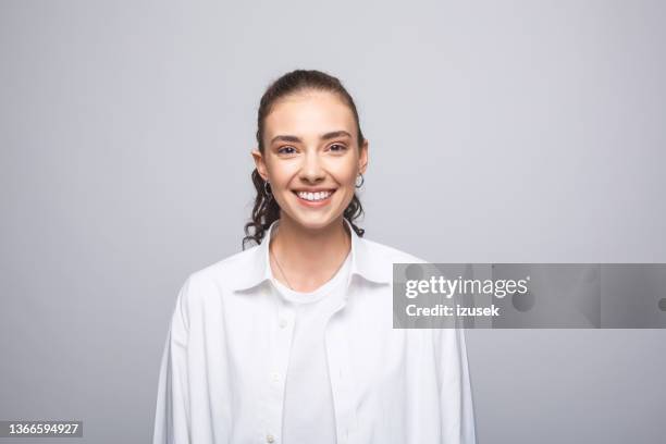 cheerful young woman in white shirt - paardenstaart haar naar achteren stockfoto's en -beelden
