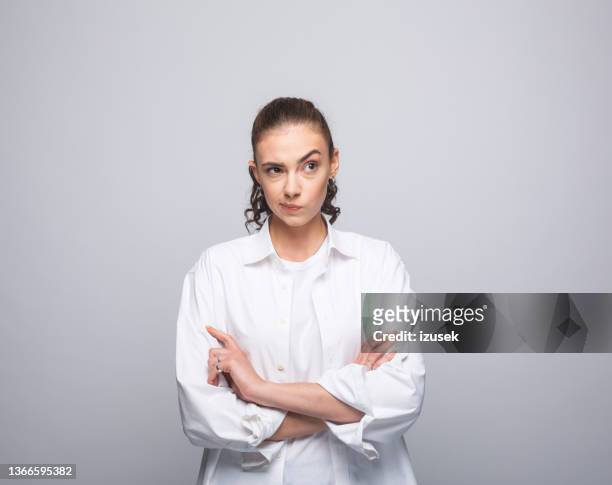 confused young woman in white shirt - raised eyebrows imagens e fotografias de stock