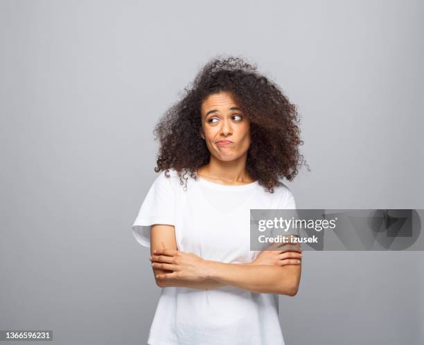 confused young woman in white t-shirt - curly hair woman white shirt stock pictures, royalty-free photos & images