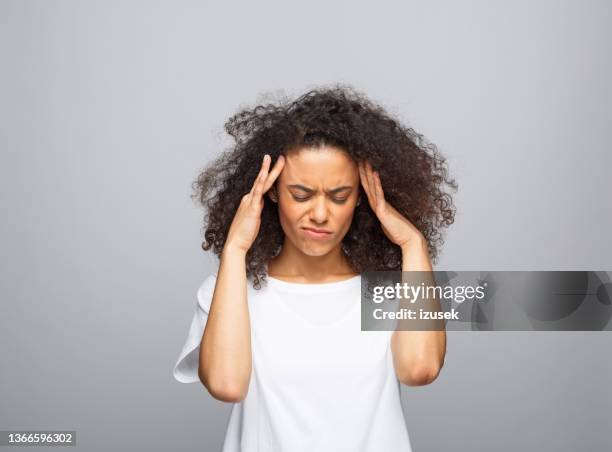 confused young woman in white t-shirt - hand in hair imagens e fotografias de stock