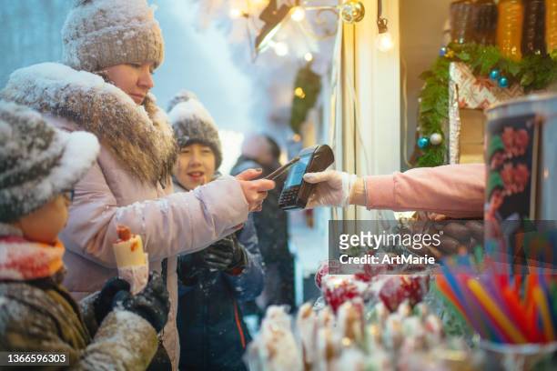 familie auf dem weihnachtsmarkt - asian eating hotdog stock-fotos und bilder