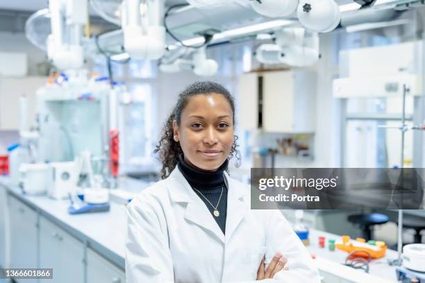 portrait of confident woman scientist in laboratory - black lab stockfoto's en -beelden