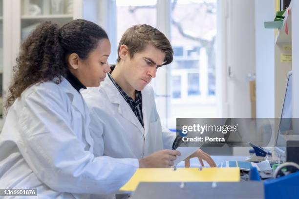 deux scientifiques examinent les résultats d’expériences en laboratoire - biochimiste photos et images de collection