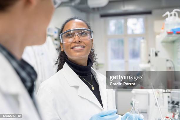 scientist discussing with male colleague while working in a lab - science research stock pictures, royalty-free photos & images