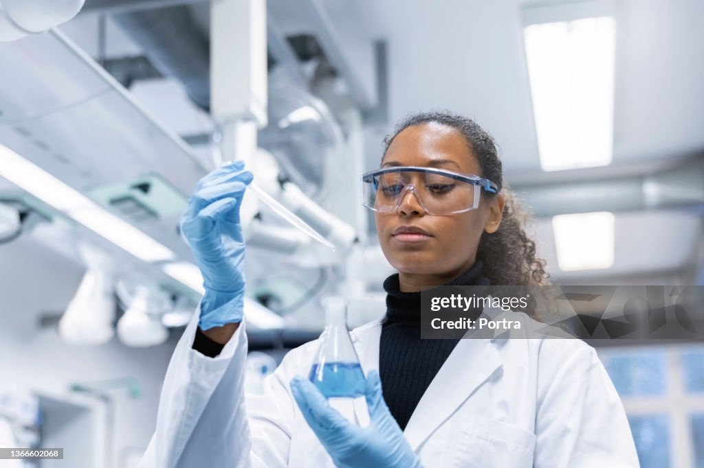 Mujer científica experimentando con productos químicos en el laboratorio