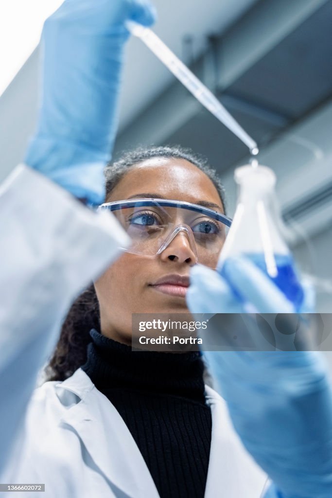 Mujer técnica de laboratorio haciendo experimentos en laboratorio