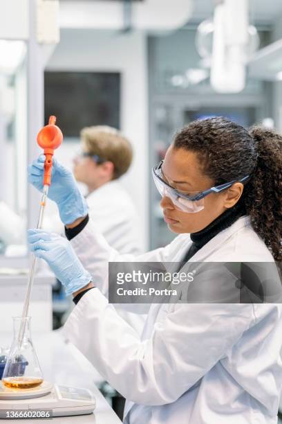 woman in laboratory examining new potions for the scientific research - dropper bottle stock pictures, royalty-free photos & images