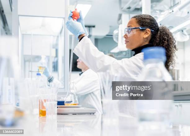 woman chemistry researcher conducting an experiment in a laboratory - drug discovery stock pictures, royalty-free photos & images