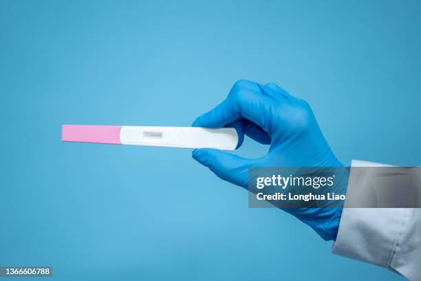 a pair of female hands holding a pregnancy test - ovulation stock-fotos und bilder