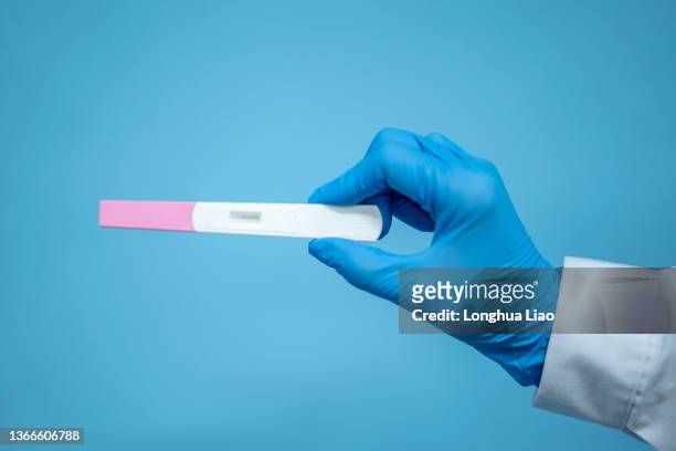a pair of female hands holding a pregnancy test - ovulation stock pictures, royalty-free photos & images