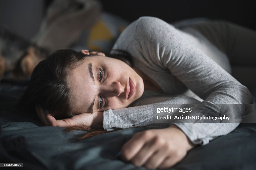 Depressed woman in bed.