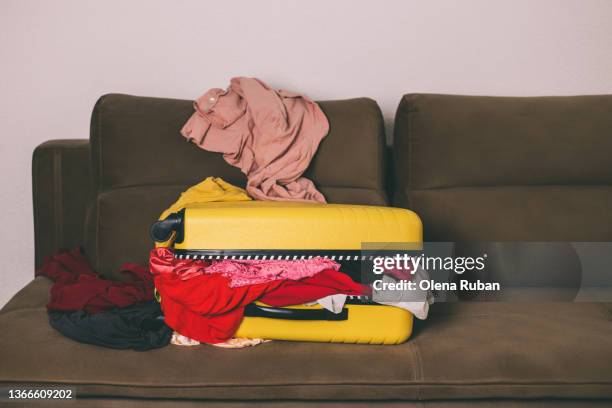 overflowing suitcase with bright color clothes. - yellow suitcase stock pictures, royalty-free photos & images