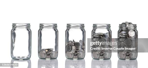 stack of coins bottle - coin stack stock-fotos und bilder