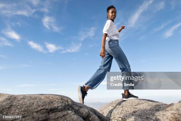 young woman walking along a boulder - lightweight stock pictures, royalty-free photos & images