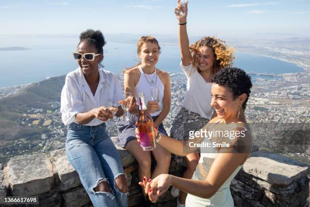 a group of girlfriends who've just popped a bottle - african travel smile foto e immagini stock