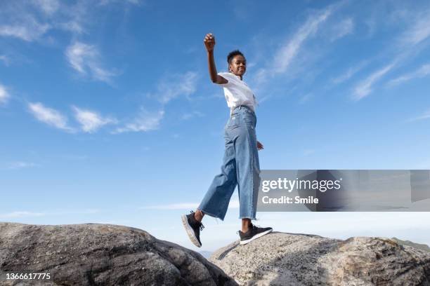 young woman dancing on a rock - leve imagens e fotografias de stock