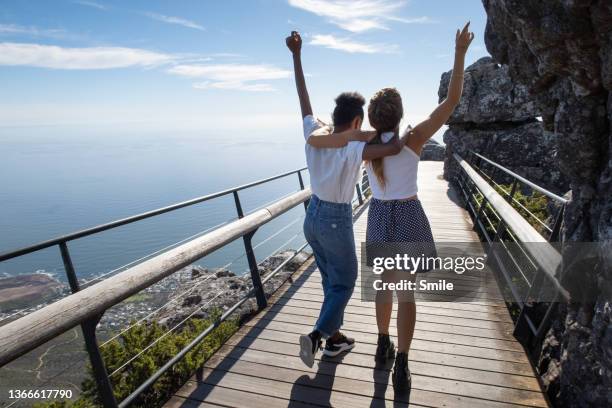 two friends dancing on a scenic bridge - african travel smile foto e immagini stock