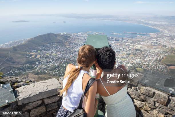 two friends looking through tourist telescope - table mountain stock pictures, royalty-free photos & images