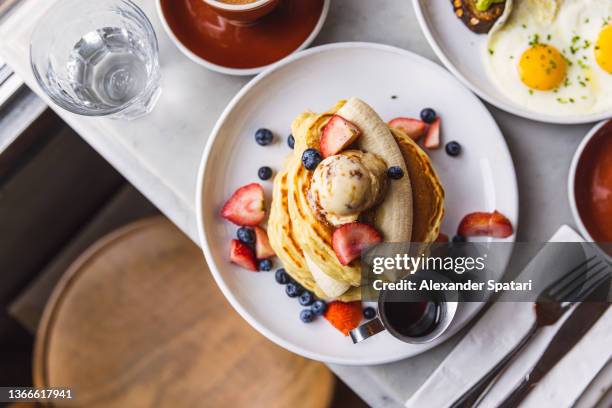 pancakes with banana, strawberry and blueberry served in a cafe for breakfast, high angle view - pancake 個照片及圖片檔