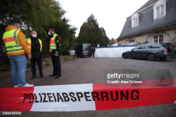 Police stand outside a building of Heidelberg University following a shooting that left the attacker dead, one victim dead and three others wounded...