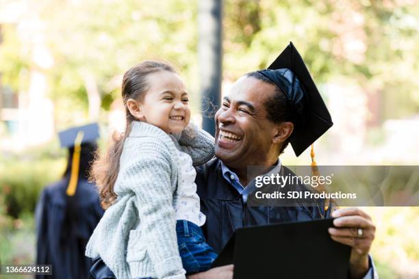 little girl makes graduating grandfather laugh with silly face - old university stock pictures, royalty-free photos & images