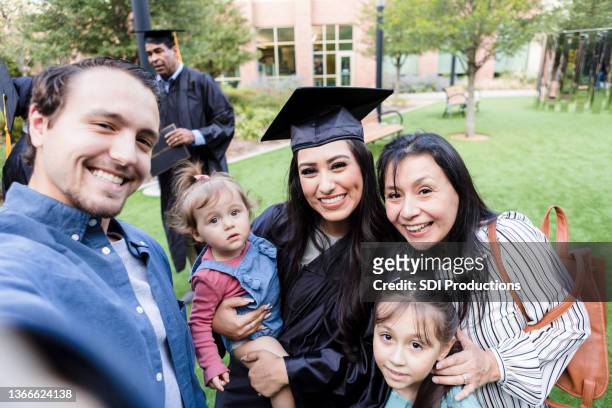 Man takes selfie of family at wife's graduation