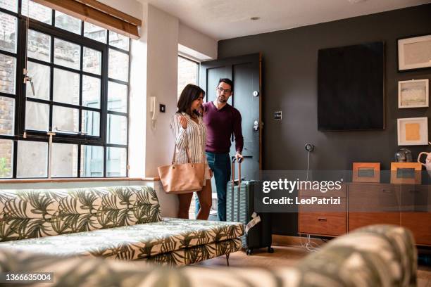 jeune couple entrant dans leur maison louée pour des vacances - entering photos et images de collection