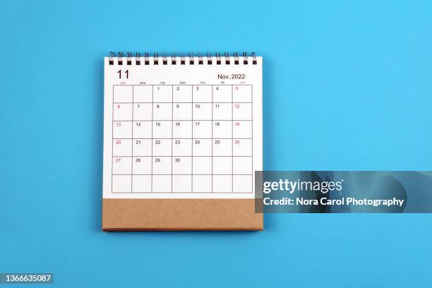 november 2022 desk calendar on blue background - noviembre fotografías e imágenes de stock