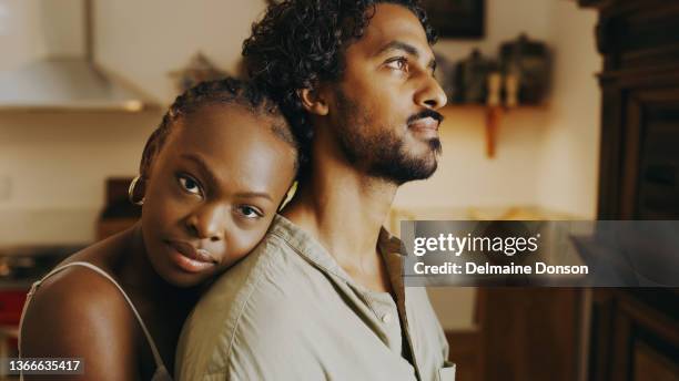 shot of an attractive young woman hugging her boyfriend while bonding with him at home - sad wife stock pictures, royalty-free photos & images