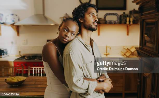 shot of an attractive young woman hugging her boyfriend while bonding with him at home - relationship difficulties photos stock pictures, royalty-free photos & images