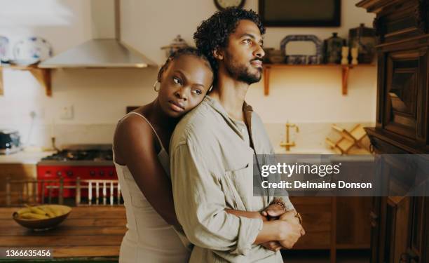 shot of an attractive young woman hugging her boyfriend while bonding with him at home - mourner imagens e fotografias de stock