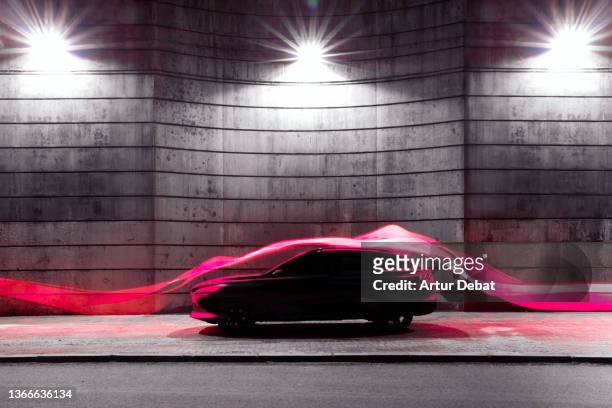 modern car with futuristic aerodynamic red light trail flowing in cool stage. - night at the net stockfoto's en -beelden