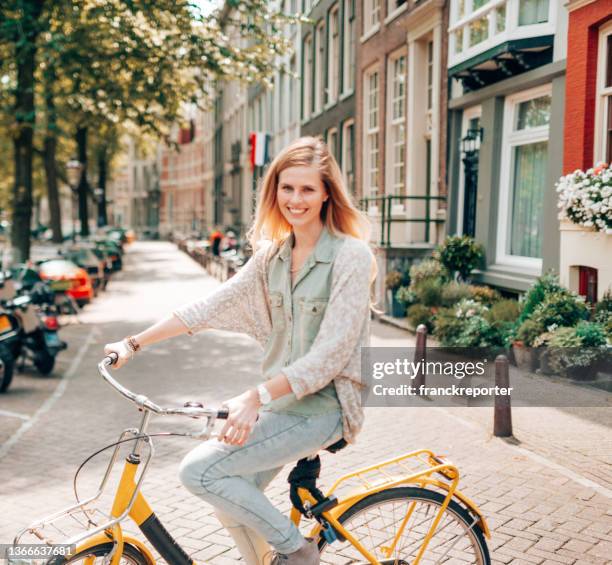 woman cycling in amsterdam - amsterdam cycling stock pictures, royalty-free photos & images