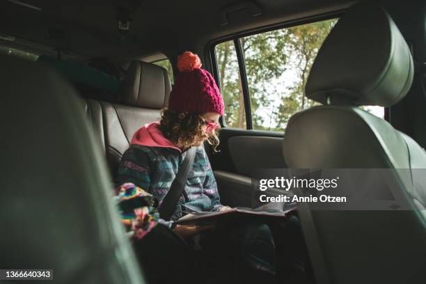 girl reading in car - annie otzen stock pictures, royalty-free photos & images