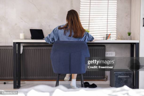 brünette sitzt im home office - brunette sitting at desk stock-fotos und bilder