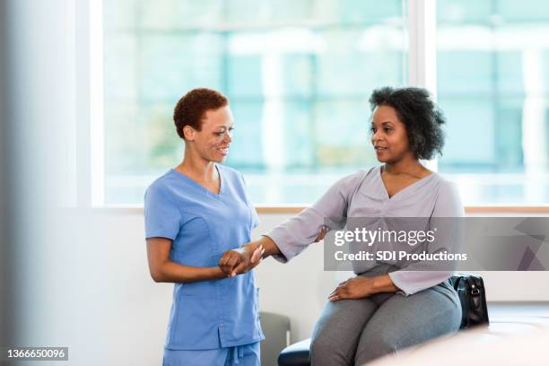 physical therapist works with female patient - hold wrists imagens e fotografias de stock